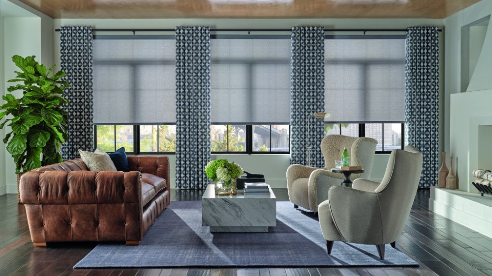 Custom drapery layered with shades in a living room